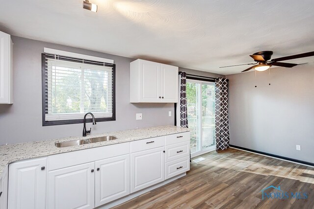 kitchen with a wealth of natural light, light hardwood / wood-style floors, ceiling fan, and sink