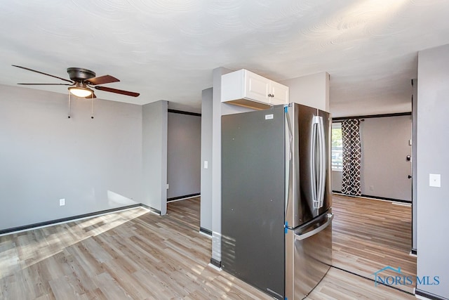 kitchen featuring ceiling fan, light hardwood / wood-style flooring, stainless steel fridge, and white cabinetry