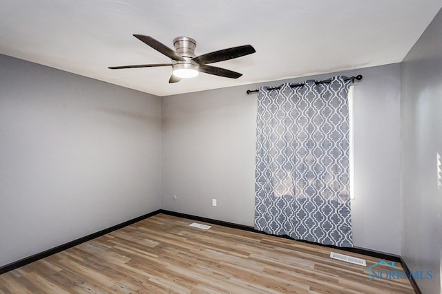 empty room with ceiling fan and light hardwood / wood-style flooring