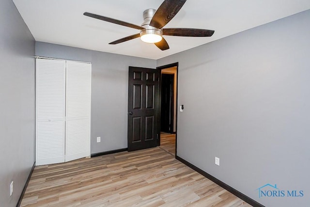 837 Burke Glen Rd, Toledo, OH 43607 - unfurnished bedroom featuring ceiling fan, baseboards, light wood-style floors, and a closet