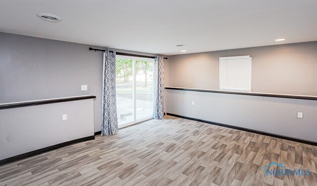 unfurnished room with light wood-type flooring