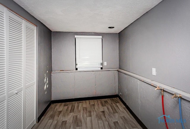 837 Burke Glen Rd, Toledo, OH 43607 - spare room featuring wood finished floors, a textured ceiling, and baseboards