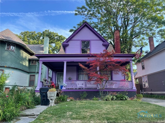 victorian home with a front lawn and covered porch