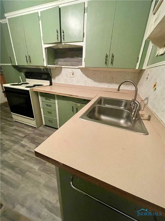 kitchen with dark hardwood / wood-style floors, green cabinets, white electric range oven, and sink