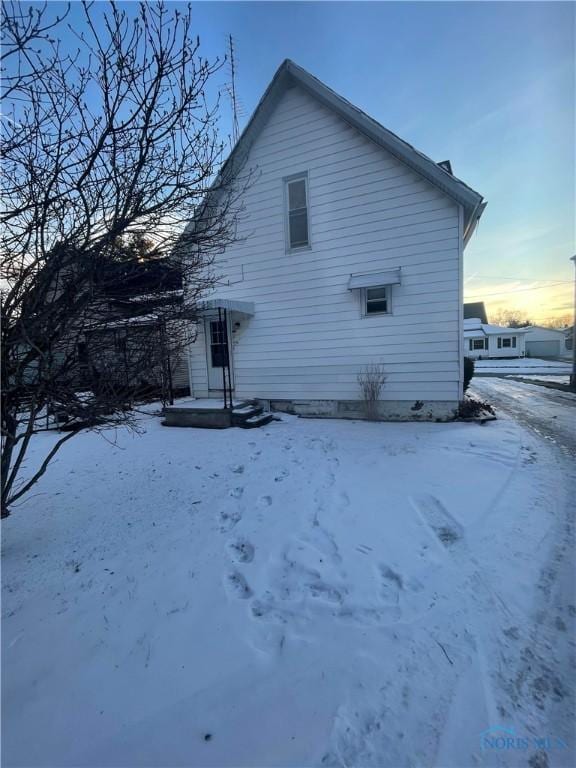 view of snow covered rear of property