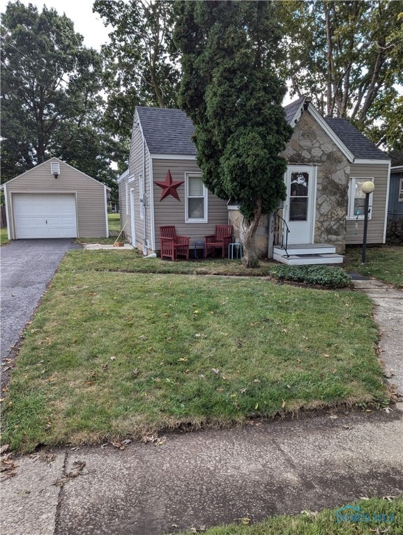 view of front facade featuring a garage, an outdoor structure, and a front lawn