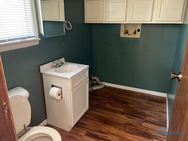 bathroom with hardwood / wood-style flooring, vanity, and toilet