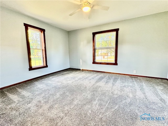 carpeted spare room featuring ceiling fan