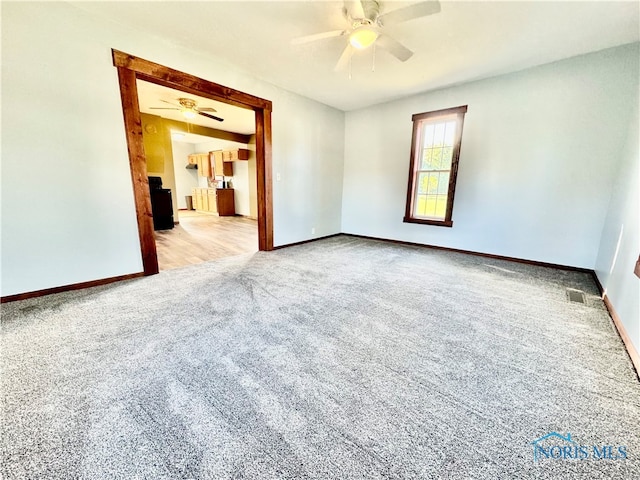 carpeted spare room with ceiling fan