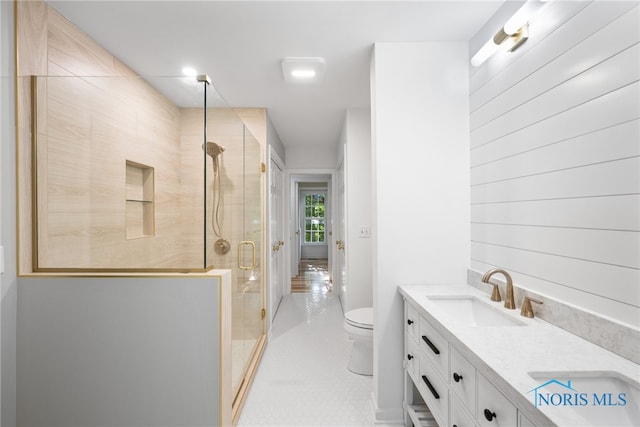 bathroom with tile patterned floors, a shower with door, vanity, and toilet