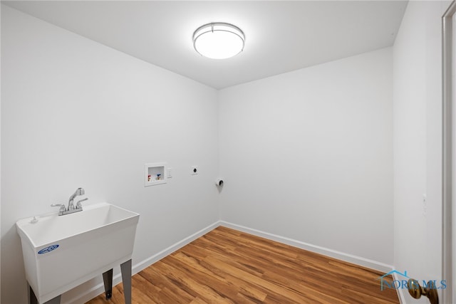 washroom featuring washer hookup, hardwood / wood-style floors, electric dryer hookup, and sink