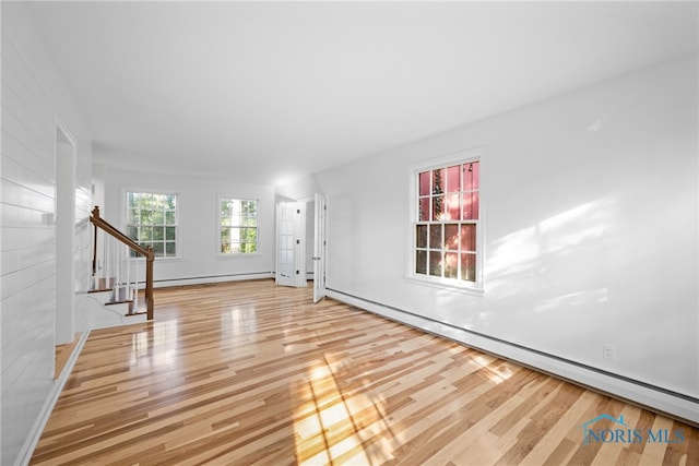 unfurnished living room featuring light hardwood / wood-style flooring and baseboard heating