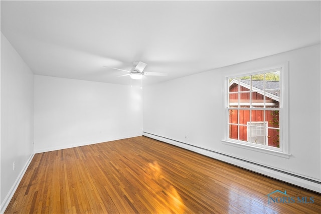 spare room featuring wood-type flooring, ceiling fan, and a baseboard radiator