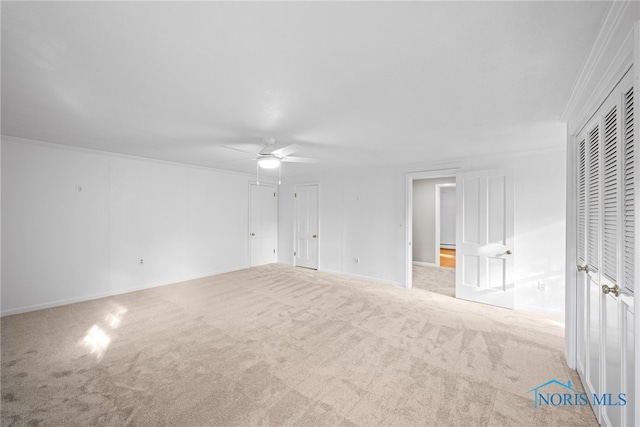 spare room with ornamental molding, ceiling fan, and light colored carpet