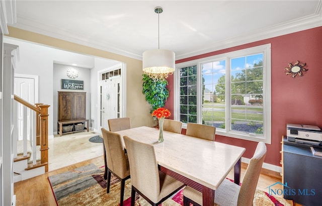 dining area featuring a notable chandelier, crown molding, light hardwood / wood-style floors, and a wealth of natural light