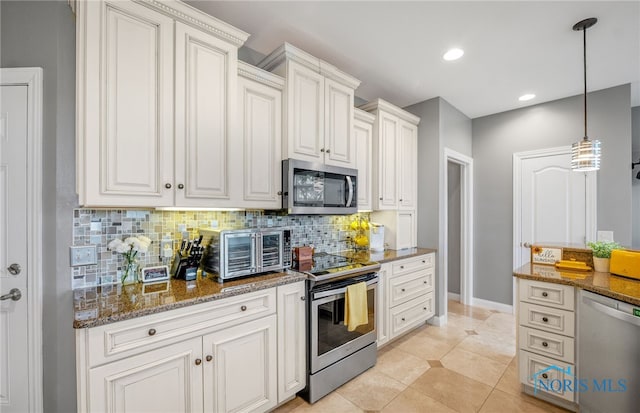 kitchen with light tile patterned floors, tasteful backsplash, white cabinetry, appliances with stainless steel finishes, and dark stone counters