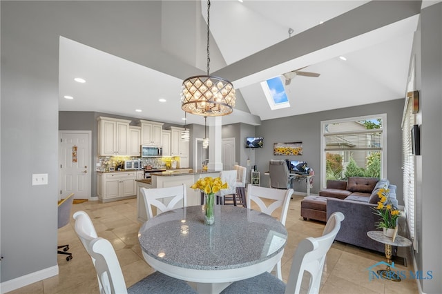 dining space with ceiling fan with notable chandelier, beam ceiling, light tile patterned floors, and high vaulted ceiling