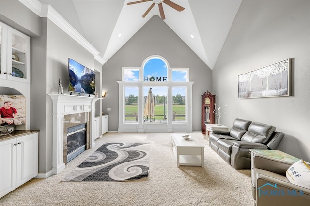 carpeted living room featuring ceiling fan, a fireplace, and high vaulted ceiling