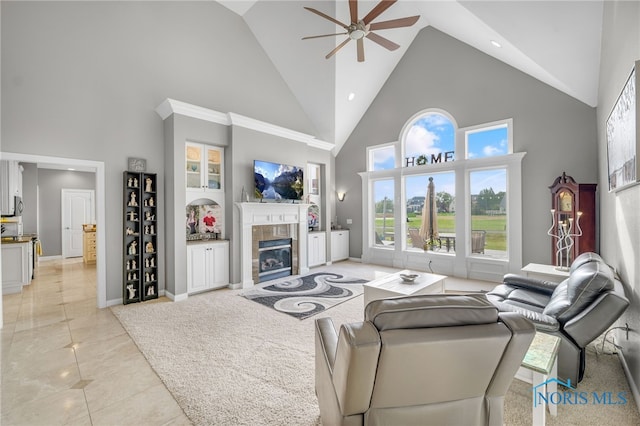 tiled living room with high vaulted ceiling, ceiling fan, and a tile fireplace