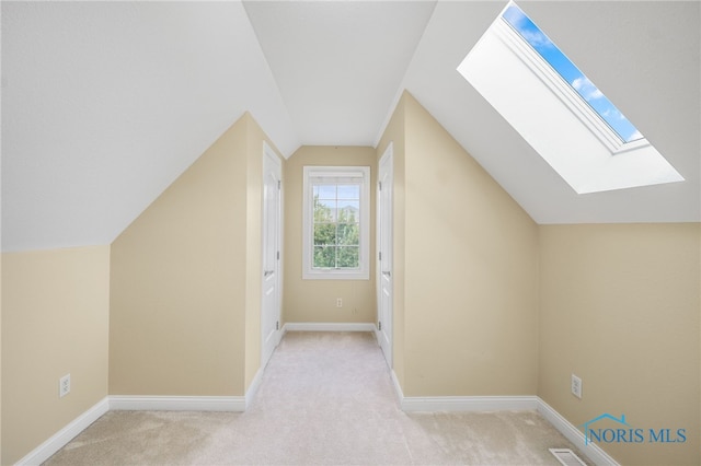 additional living space with light colored carpet and vaulted ceiling