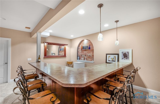 bar with light carpet and hanging light fixtures