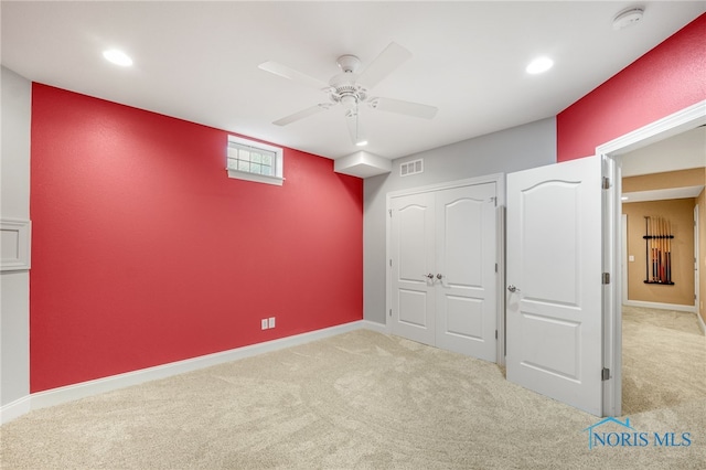 unfurnished bedroom with light carpet, a closet, and ceiling fan