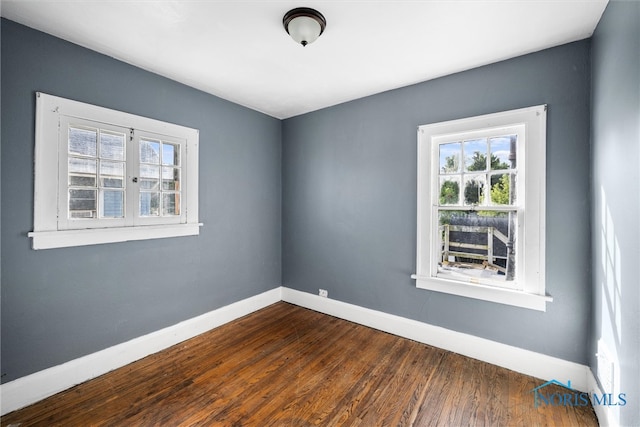 empty room with dark hardwood / wood-style flooring