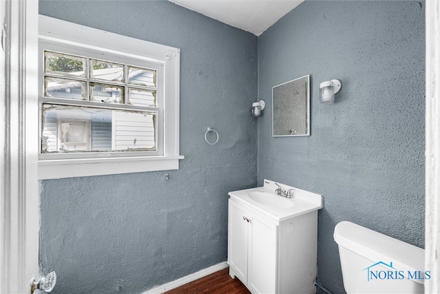 bathroom featuring vanity, hardwood / wood-style floors, and toilet