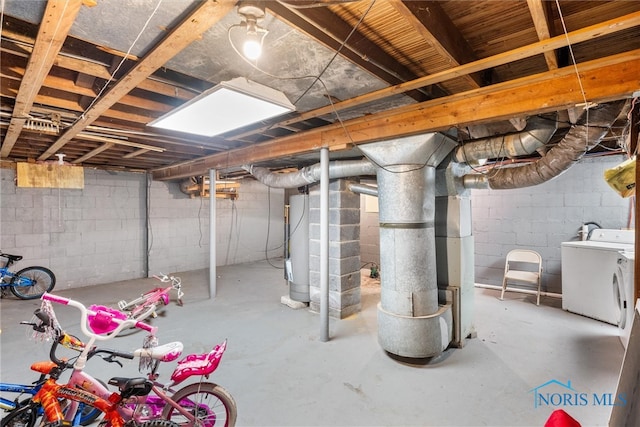 basement featuring washer and clothes dryer and water heater