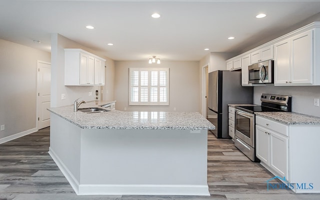 kitchen with stainless steel appliances, white cabinetry, kitchen peninsula, and light wood-type flooring