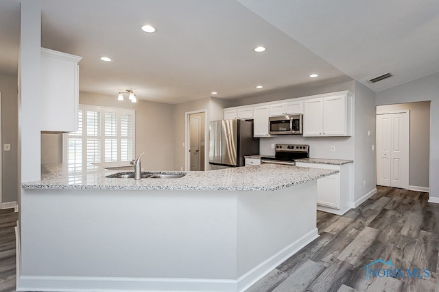 kitchen with stainless steel appliances, white cabinets, kitchen peninsula, and sink