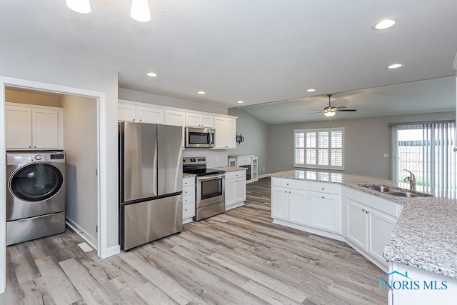 kitchen with white cabinets, washer / clothes dryer, appliances with stainless steel finishes, and sink