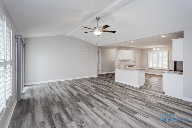 unfurnished living room with lofted ceiling with beams, dark hardwood / wood-style floors, and ceiling fan