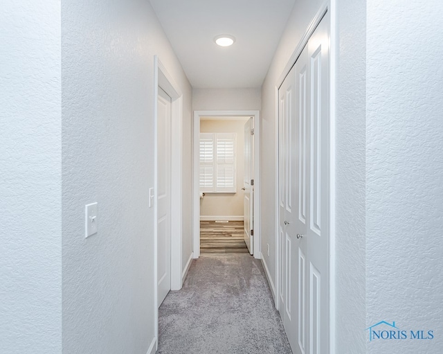 hallway with light colored carpet