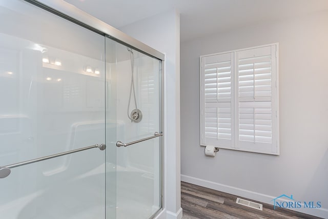 bathroom with wood-type flooring and walk in shower