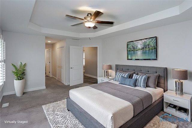 bedroom featuring a tray ceiling, ceiling fan, and carpet floors