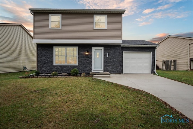 view of property with a garage and a lawn