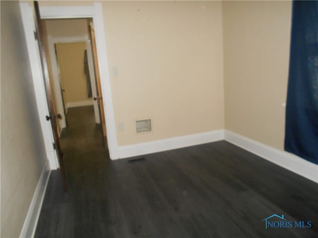 spare room with dark wood-type flooring