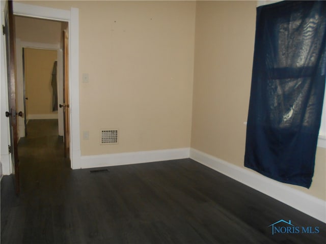 spare room with dark hardwood / wood-style flooring