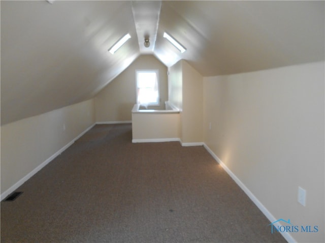 bonus room featuring lofted ceiling and dark colored carpet