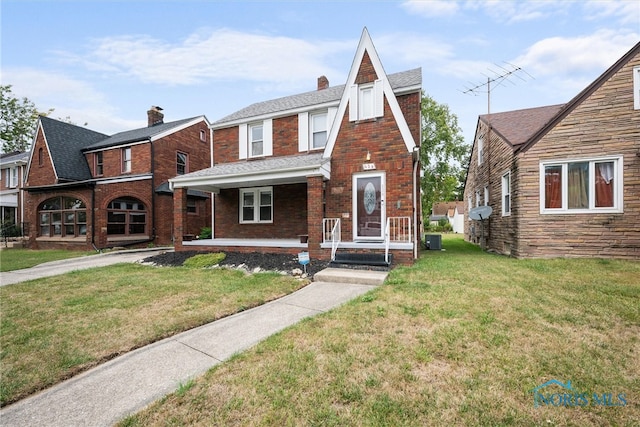 view of front of house with central AC and a front yard