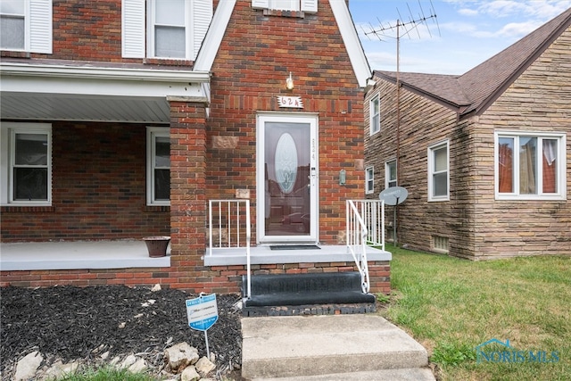 doorway to property featuring a lawn