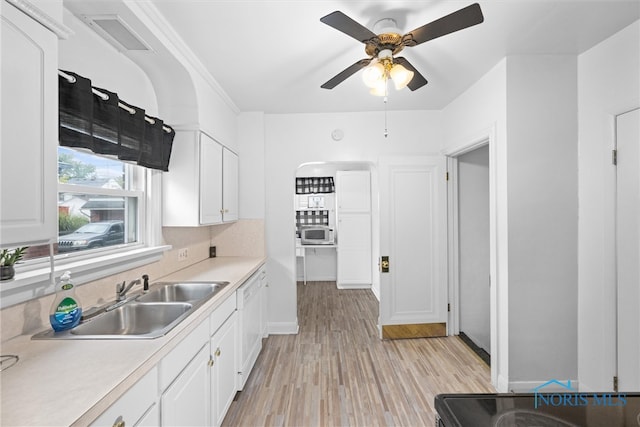 kitchen featuring ceiling fan, light hardwood / wood-style flooring, sink, and white cabinetry