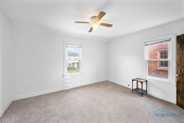 carpeted spare room with ceiling fan