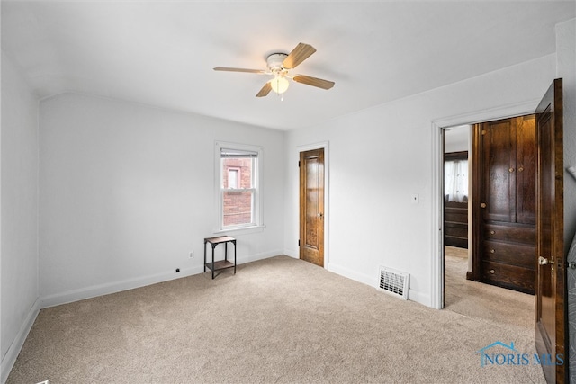 unfurnished bedroom with ceiling fan, lofted ceiling, and light carpet