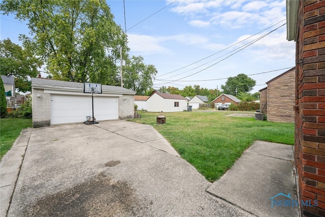 view of yard with a garage and central AC unit