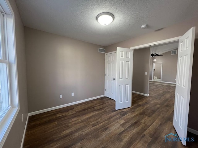 unfurnished bedroom with dark hardwood / wood-style floors and a textured ceiling