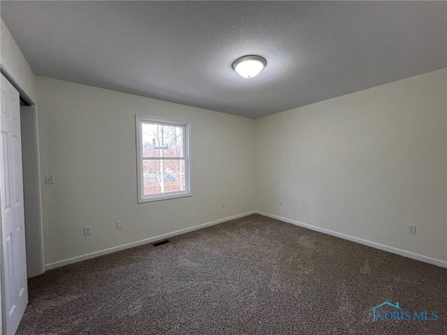 carpeted spare room with a textured ceiling