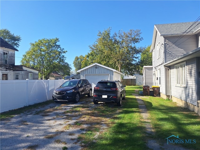 view of yard featuring a garage and an outbuilding