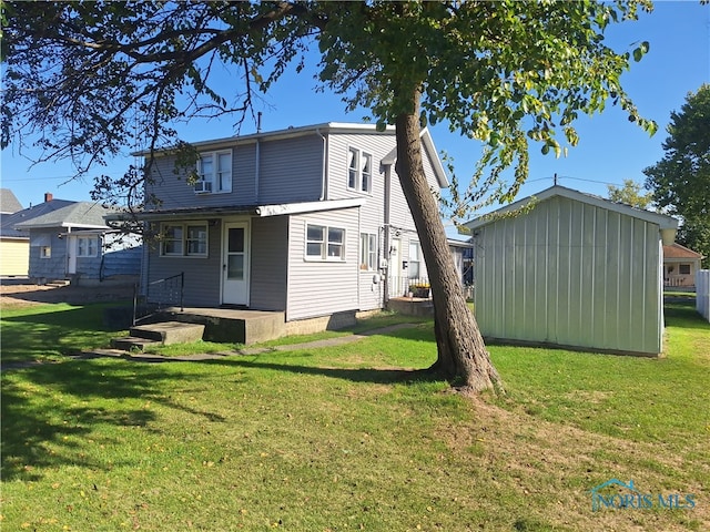 back of house featuring a storage shed and a lawn